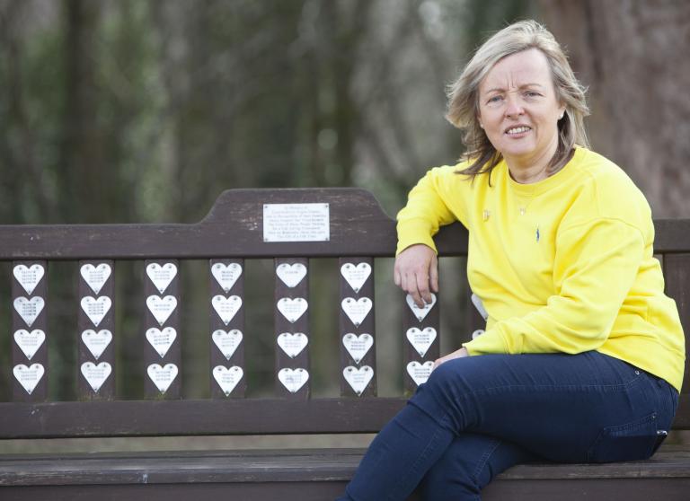 Woman sits on memorial bench