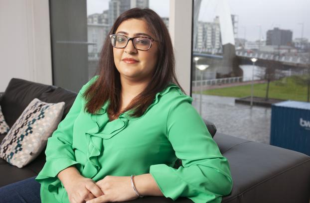 A women with an Asian background sitting on the sofa