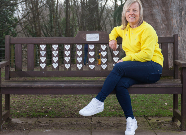 Elaine Kennedy sitting on memorial bench